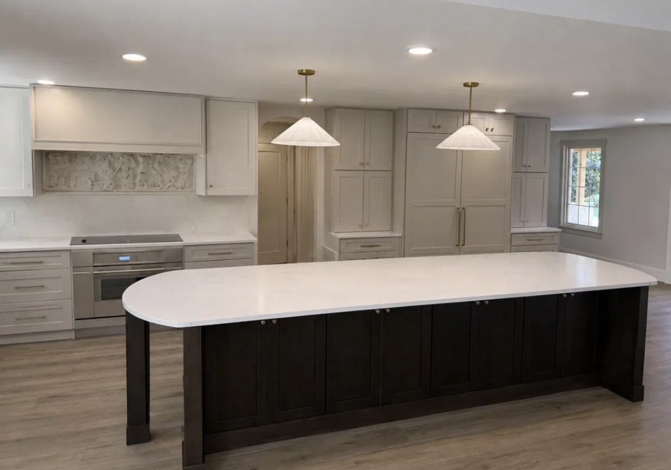 Kitchen with long quartz island and paneled refrigeration