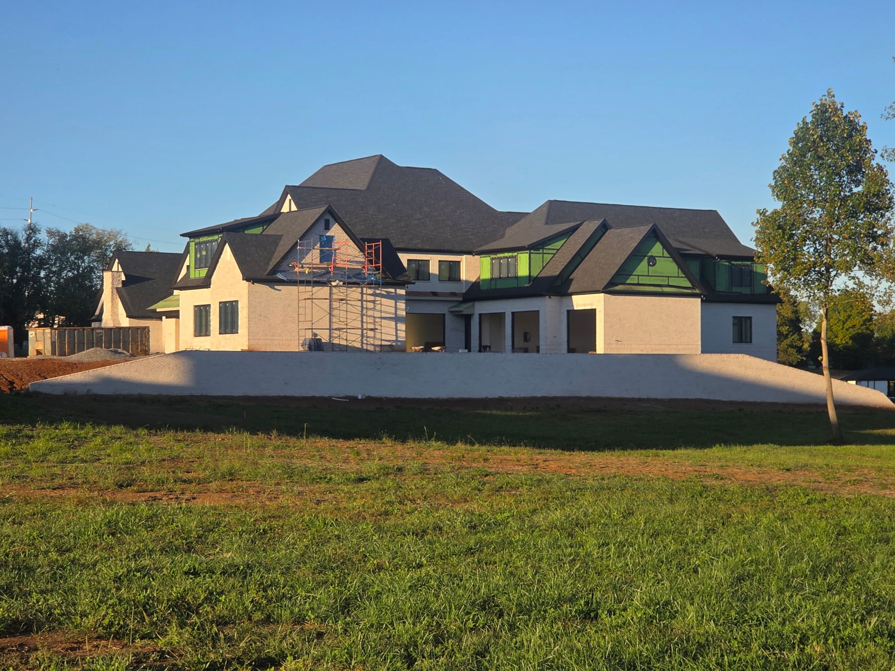 Side wing with scaffolding at a gable and terrace wall below
