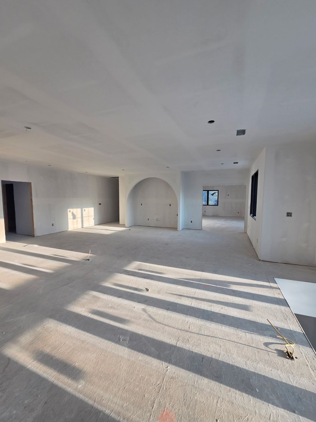 Open living area with a drywall arched alcove